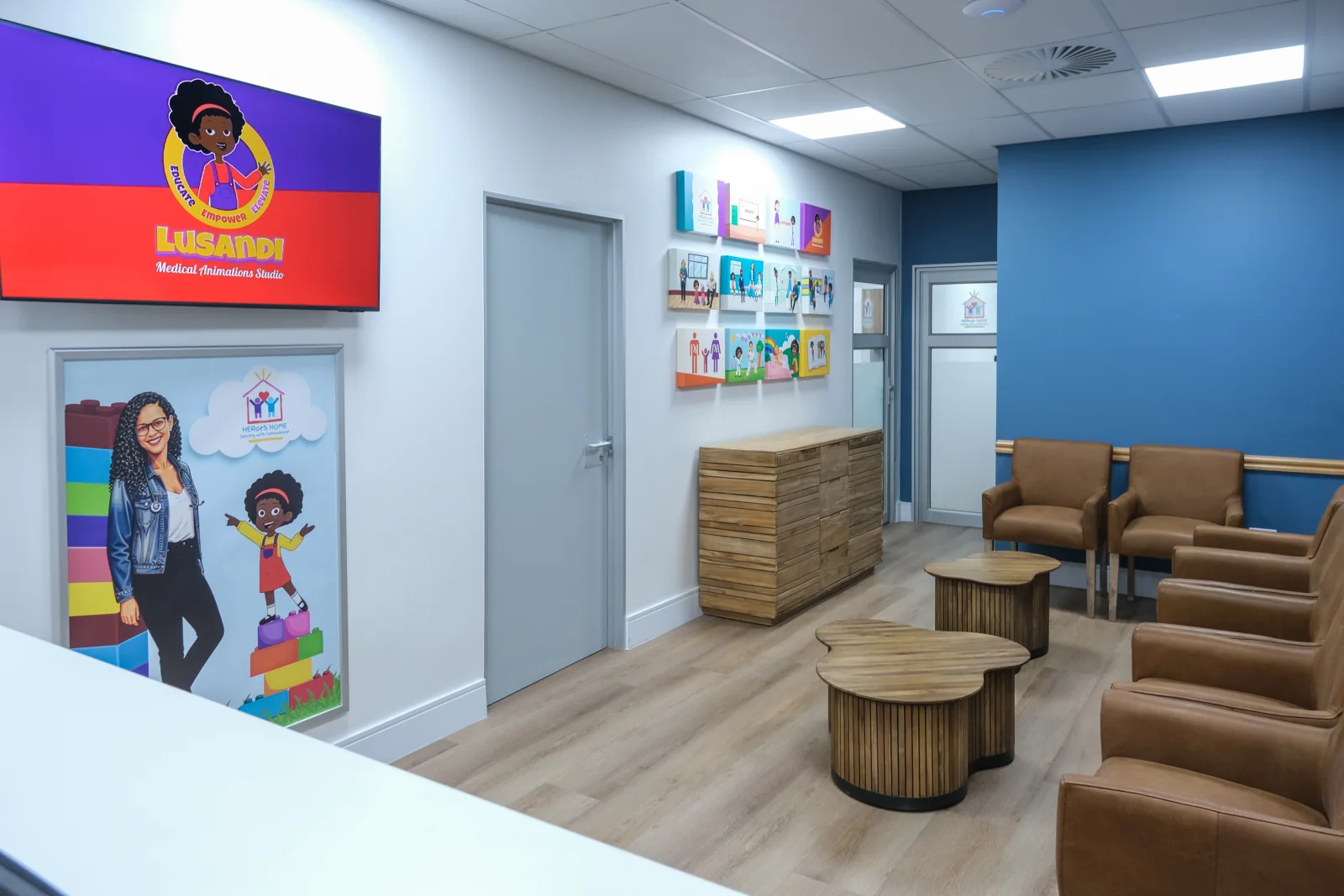 HERoeS HOME reception and waiting area with Lusandi branding, children’s artwork, and seating