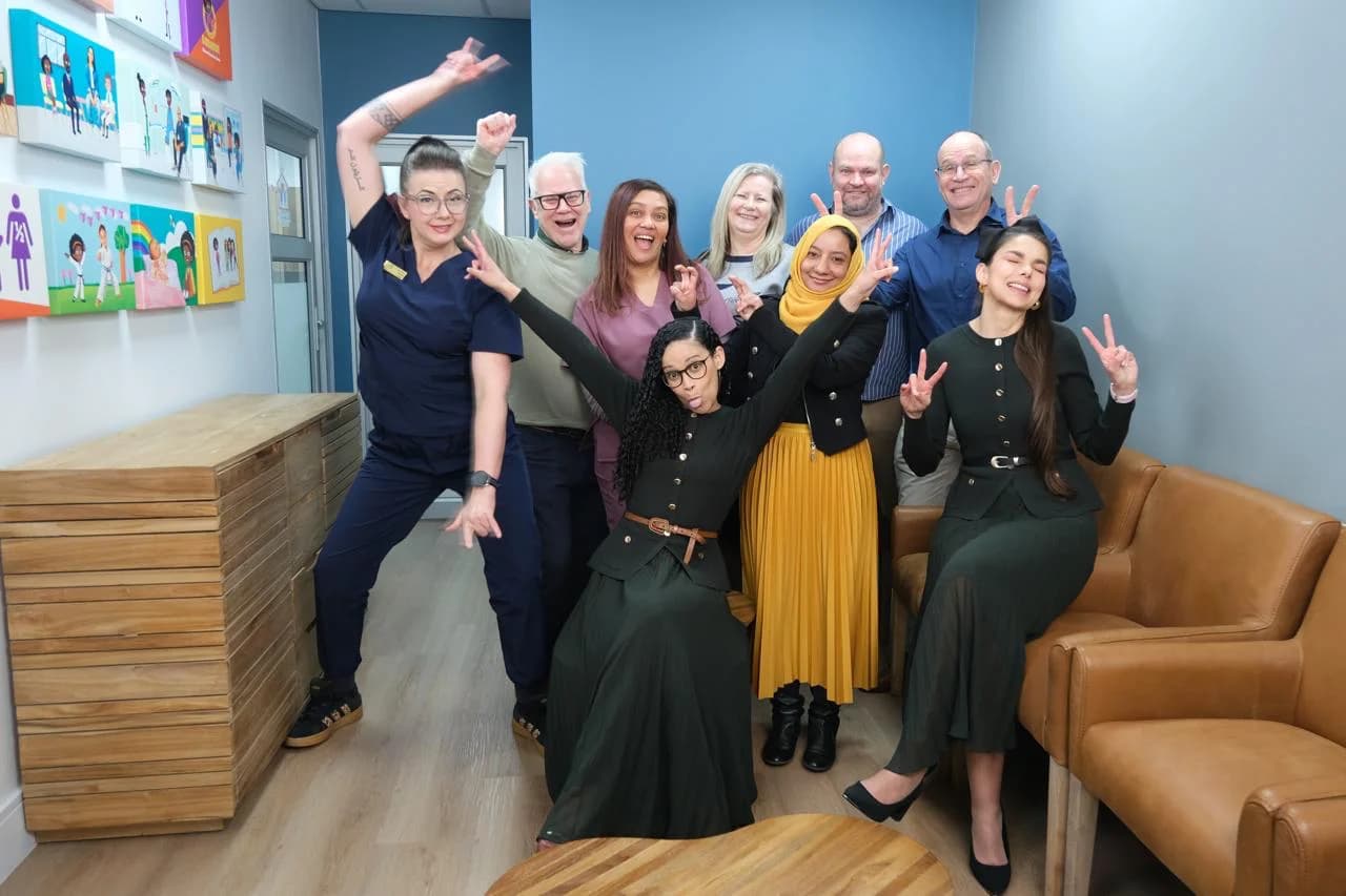ACT Processing facility team posing playfully together in the HERoeS HOME care space