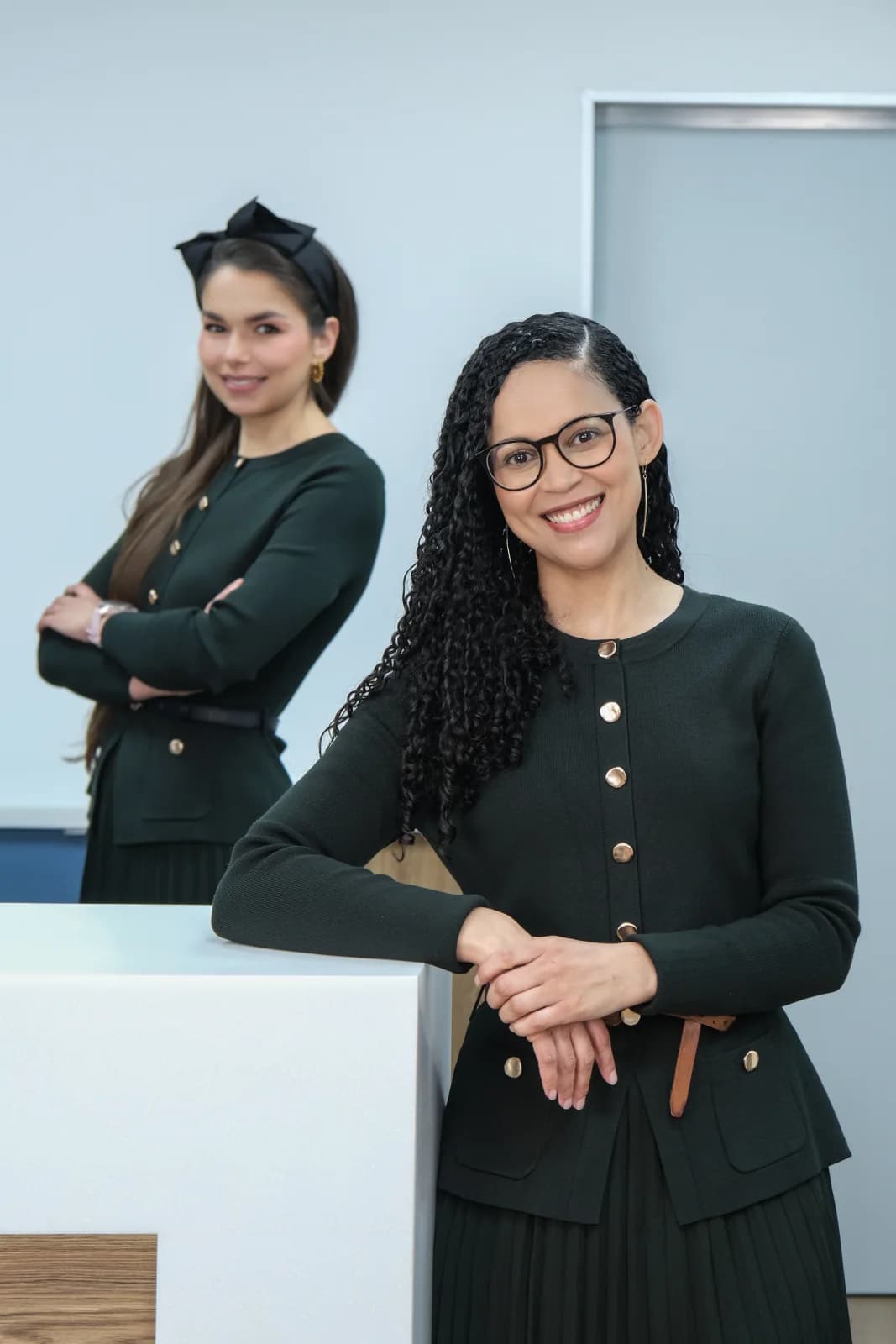Two HERoeS HOME team members smiling near the reception desk